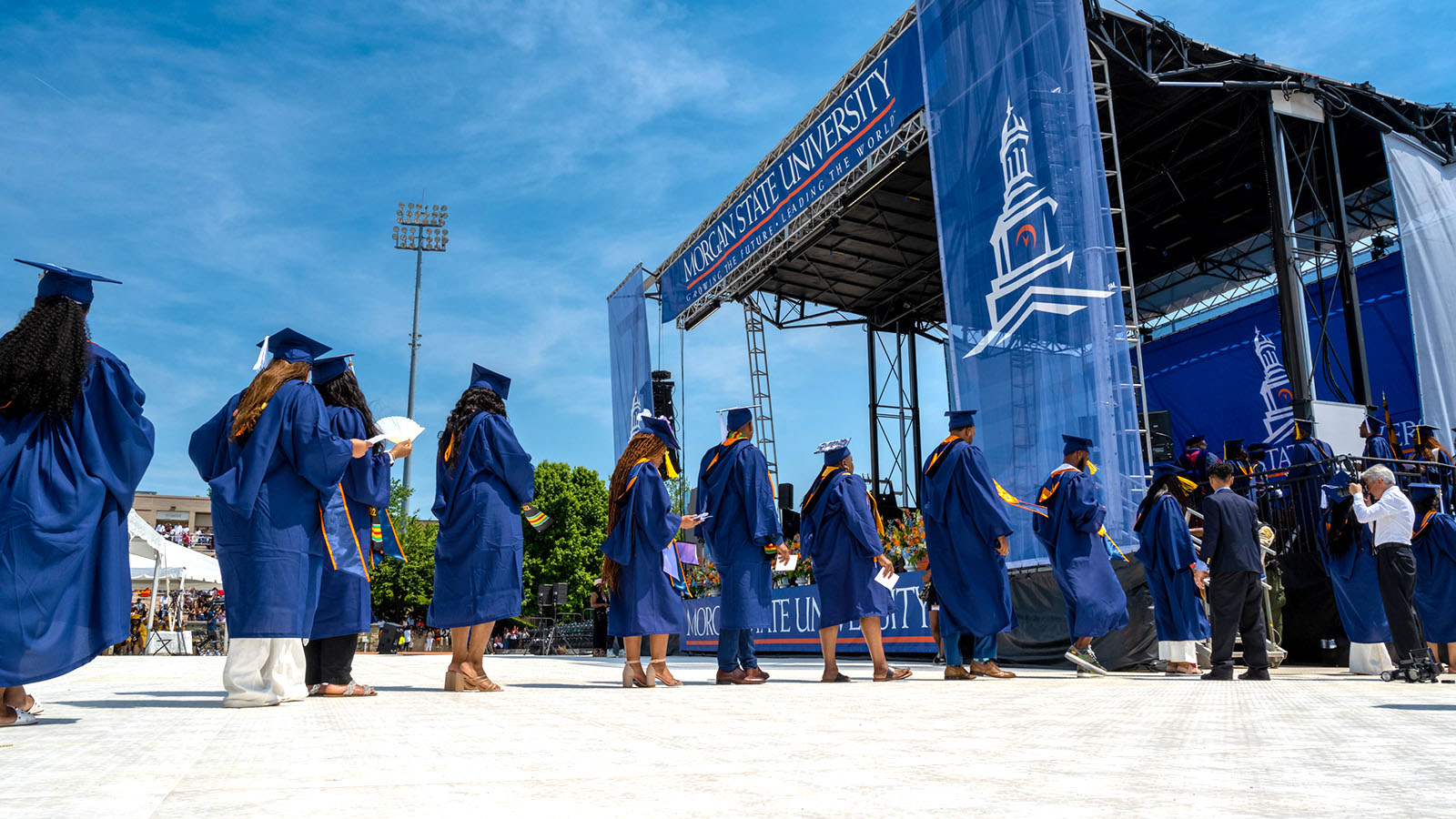 graduates walking across platform to the stage