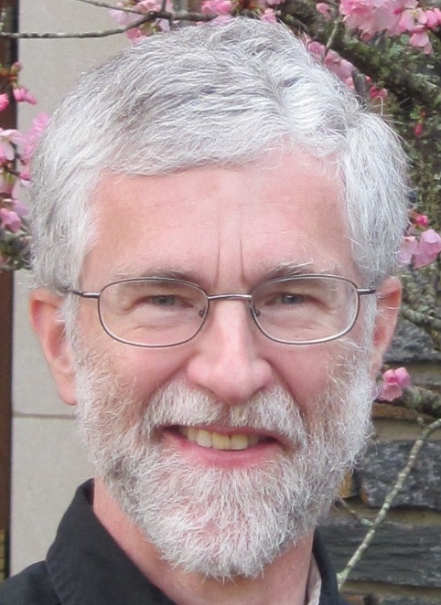 Dr. Edwin Hostetter.  A smiling man wearing glasses with white hair and white beard.  