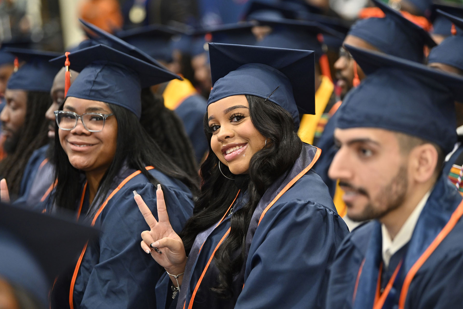 female graduating student holding up a peace sign