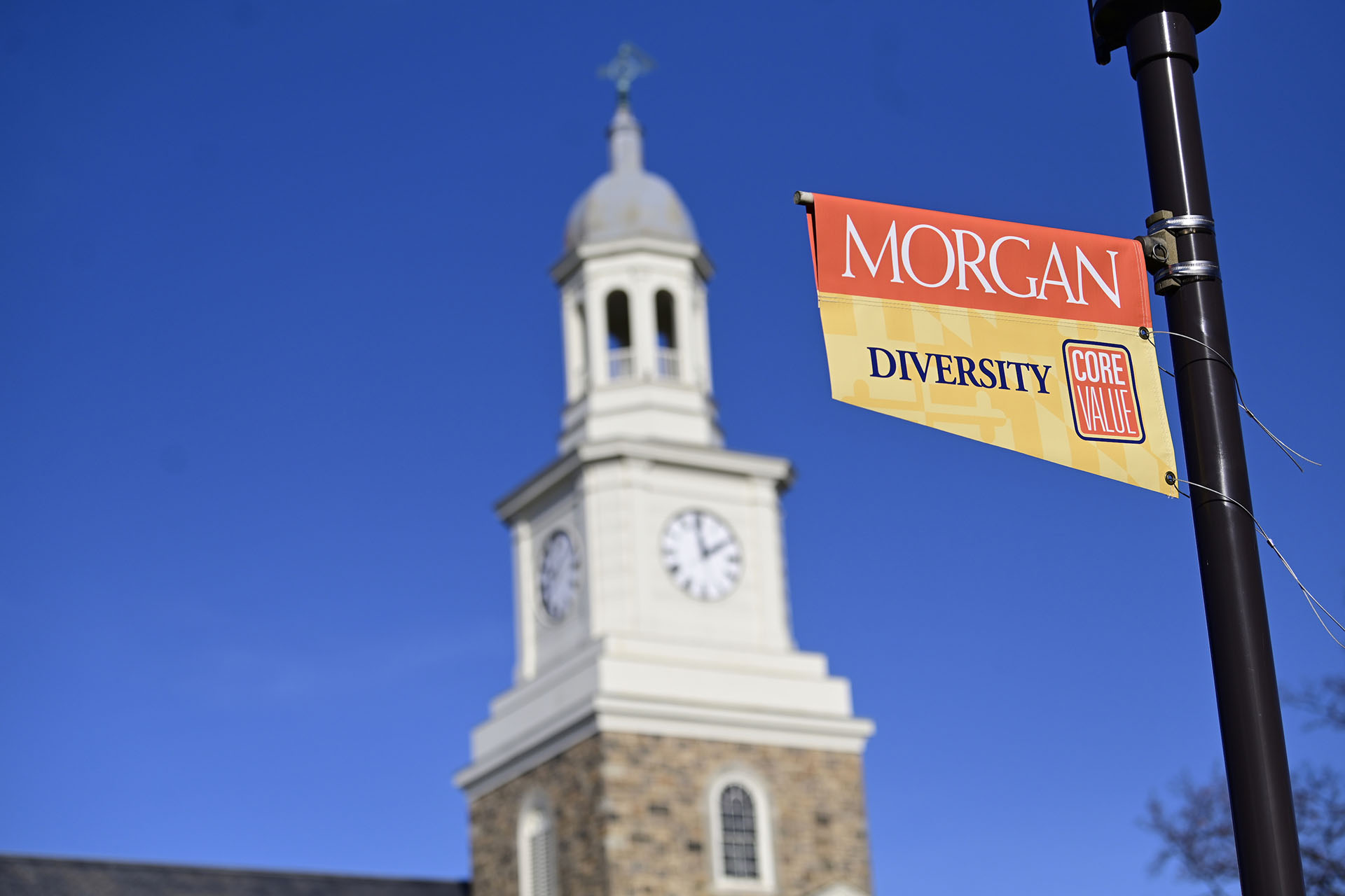 Diversity pole flag in front of Holmes Hall clock tower